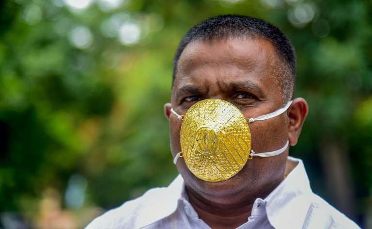 Un Indien porte un masque en or pour se protéger du coronavirus
